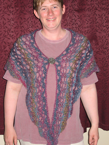 Lacy shawl on big needles with crochet flowers