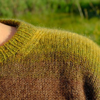 Detailed view of neckline shaping from the front of the sweater.