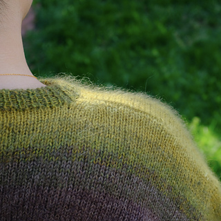 Detailed view of neckline shaping from the back of the sweater.