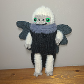 Folklore yeti is knit with Lion Brand Feels like Bliss on 3.5mm needles, and wearing outfit made with Lion Brand Wool-ease on 3.5mm needles