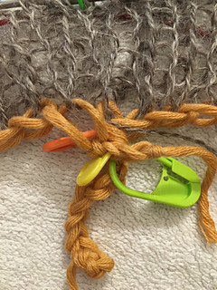 Stitch markers keeping knitting from pulling apart at the join.