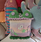 Green frog wearing a colourful sweater with sleeves and a flower in a frame