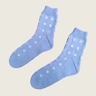The same blue socks with white eyelet embroidery laid flat on their sides.