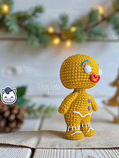 Amigurumi crochet free pattern of the Shrek Gingerbread Man with purple gumdrop buttons and white icing details.