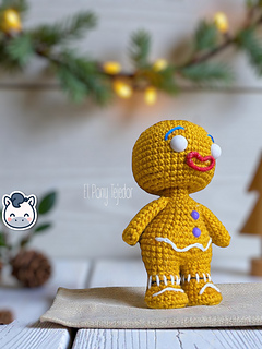 Amigurumi crochet free pattern of the Shrek Gingerbread Man with purple gumdrop buttons and white icing details.