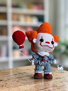Handmade Pennywise amigurumi inspired by IT featuring a red balloon, a geek crochet pattern PDF perfect for Halloween and horror fans.