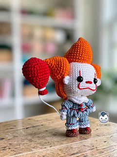 Handmade Pennywise amigurumi inspired by IT featuring a red balloon, a geek crochet pattern PDF perfect for Halloween and horror fans.