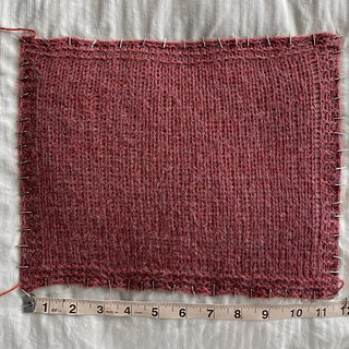 Width during aggressive blocking, knit on 4.5mm and 5mm needles (smaller size for purl rows): ~ 11.75 inches
