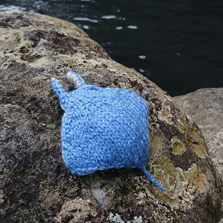 Knitted manta ray toy on the rocks