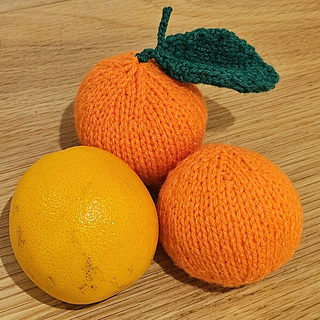 Real orange with knitted oranges