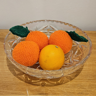 Knitted oranges and real orange in knitted fruit display