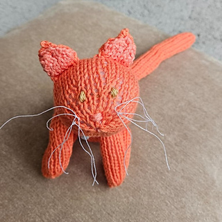 Cute ginger knitted cat with wiry whiskers