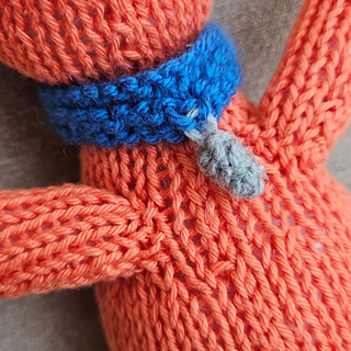 Ginger knitted cat with blue collar and bell