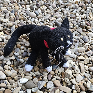 Black and white knitted cat with wiry whiskers