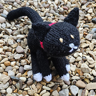 Black and white knitted cat with no whiskers