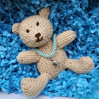 Knitted teddy bear with finger-knitted bracelet accessory idea