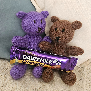 Two knitted teddy bears sharing chocolate