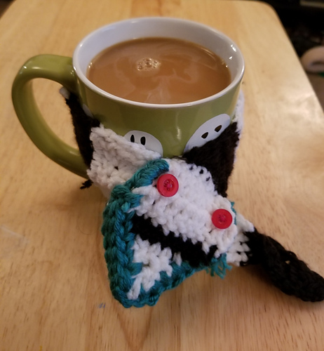 Bonus! 
To make this mug hugger you will need :

size 4 Medium weight yarn in white, black
and teal 
5.5mm hook 

Follow the instructions for the cowl , add 2 more stripes to the body so it can fit around a mug. 
For the lips still hold the yarn double.