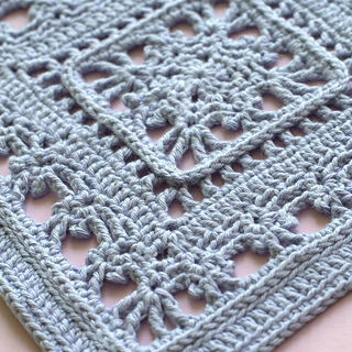 Macro photo showing stitchwork in lacy crochet square pattern