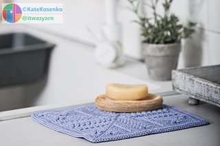 A crochet square in soft lavender cotton, with textured stitches forming a subtle ripple-effect.