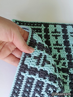 Hand holding the edge of the Pulse overlay mosaic crochet square.