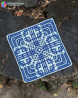 Orbit crochet square in blue on a tree stump.