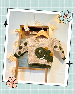 beige crochet sweater with moss green cuff, featuring a moss green dinosaur applique, mustard and moss green spikes run down the spine of the dinosaur. the dinosaur has white teeth and googly eye. the sleeves of the jumper has crochet spots sewn to them. dinotastic crochet sweater pattern for babies and toddlers by jane burns