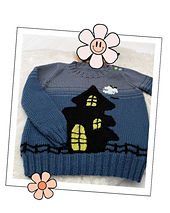 Kids Halloween jumper knitting pattern with a black haunted house pocket and knitted fence, laid flat