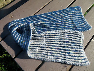 Image Description: A bulky knit scarf knit in two-colour fisherman's ribbing, forming vertical stripes in off white and dark blue.
