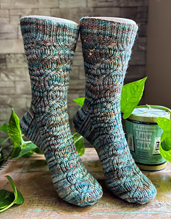 Image Description: a pair of ribbed lace socks knit in a multicolour variegated yarn
