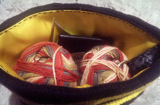 Comfortably holds 2 50g loosely wound balls dk weight yarn, my knitting notebook and my needles. And because of the interfacing, it stands up nicely so can act like a mobile yarn bowl. Perfect sock sack. 