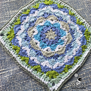 Close-up of the dahlia flower motif at the center of the granny square, highlighting petal structure and stitch definition.