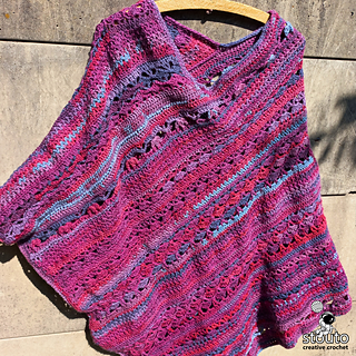 Cozy handmade crochet poncho styled for fall layering with lightweight drape, bohemian texture, and flowing striped stitch patterns.