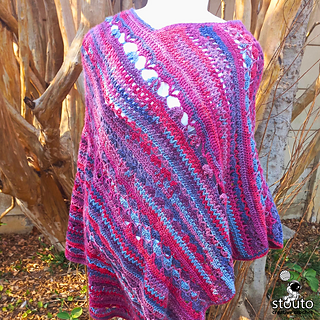 Oversized women’s crochet poncho featuring floral-inspired stitches, V-stitches, and textured rows worked in warm self-striping yarn colors.