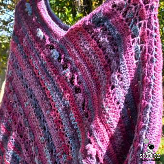 Modern women’s crochet poncho pattern displayed with soft folded construction, oversized fit, and elegant textured stitch transitions.
