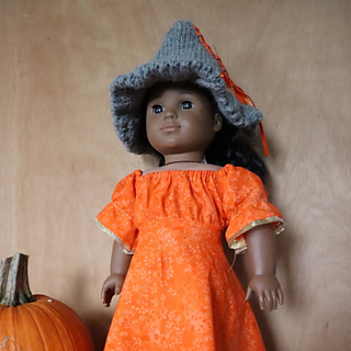 American Girl doll in grey knitted witches hat and orange dress