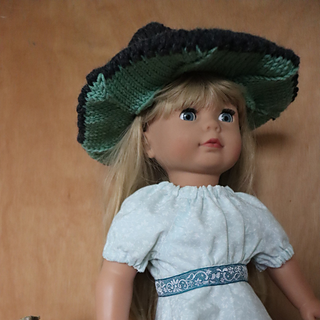 Gotz doll in green and black knitted witches hat, and a mint green dress