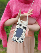 Close-up of a crocheted phone pouch, highlighting the intricate fillet crochet mesh and functional window.