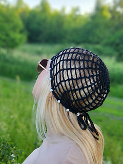 Close-up of the beaded details on a black crochet hat pattern, highlighting the craftsmanship.