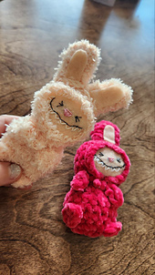 The Labubu doll is held in a person's hands, giving a sense of its small, plush size. Crochet free pattern