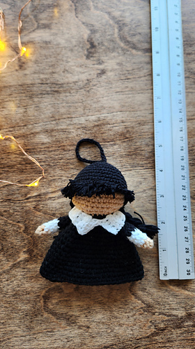 Photo comparing the size of the mini Wednesday Amigurumi to a liner