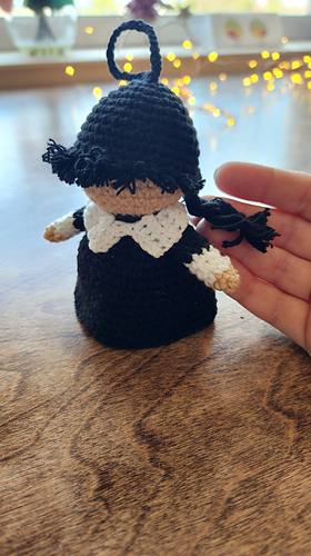 tiny crocheted doll with the keychain ring attached, ready to be used as a bag accessory.