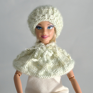 A Barbie doll with a knitted beret with alternating purl and twisted knit stitches. Please note the pattern for the cape is not included.