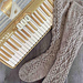 Image Description: A pair of grey knee-high socks knit in fingering-weight sock yarn.  Honeycomb Cables surround a central cable that runs along the instep and front of the leg.