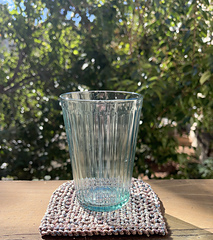 Sample of coaster in recommended yarn with a cup sitting on top of it.