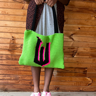 Model holds tapestry that was formed into a bag.