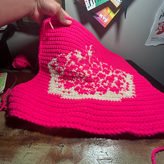 Pink and white crown tapestry lies flat on a desk