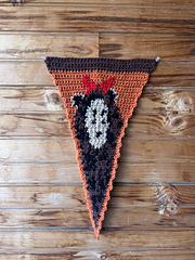 Crochet pennant against a wooden wall