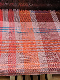 the pink towel with blue and orange and peach stripes