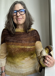 Holding a skein of Mohair Ombre 2 Ply in 781--the color and yarn used in this top.
